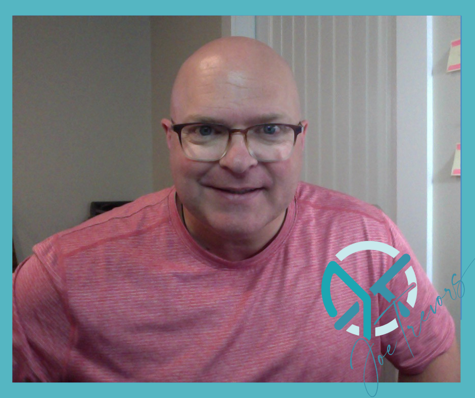 Joe Trevors, bald with glasses, smiling enthusiastically while wearing a pink salmon t-shirt with white stripes.
