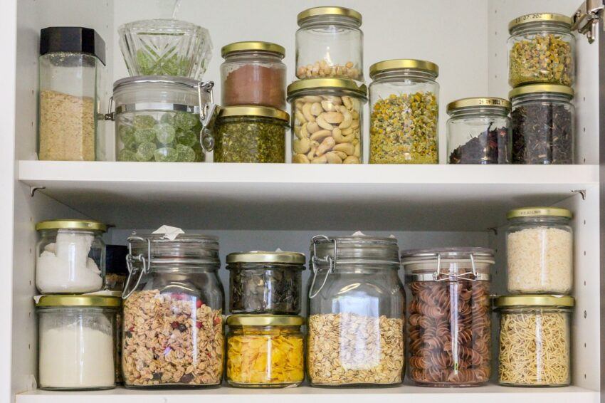 A picture of a clean pantry with beans and legumes, pastas, etc., in various-sized jars.