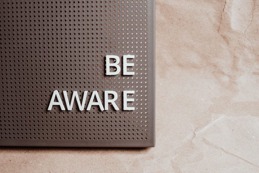 A sign with letters that can be stuck to it that reads: "Be Aware".