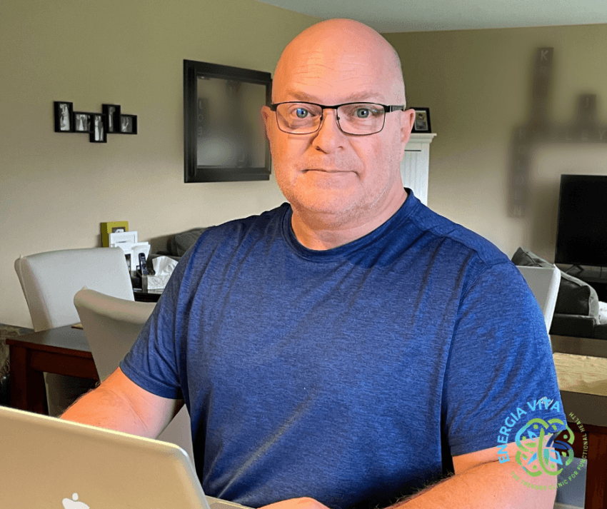 Pictured in a bright blue t-shirt and glasses, is Joseph Trevors, n.d., CFNC sitting at his MacBook in his kitchen on a Saturday after having edited, saved, and published final copy of his Habit Revolution Challenge on October 28, 2023